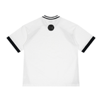 St. Padel V-Neck Jersey. White short-sleeve ringer t-shirt shown from the back, featuring black contrast trim on the collar and sleeve cuffs, with a small black circular globe graphic printed at the center of the upper back.