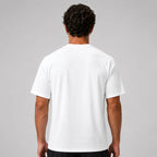 St. Padel Performance Padel T-Shirt. A man viewed from behind wearing a plain white short-sleeve athletic T-shirt against a light gray studio background.