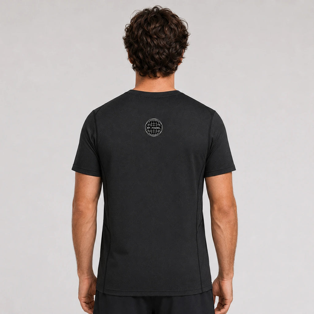 St. Padel Performance T-Shirt. A man viewed from behind wearing a black short-sleeve t-shirt with a small circular logo on the upper back, set against a plain light gray studio background.