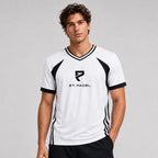 St. Padel V-Neck Jersey. A man wearing a white and black athletic t-shirt with 'ST. PADEL' and a stylized 'R' logo on the chest, photographed against a neutral gray studio background.