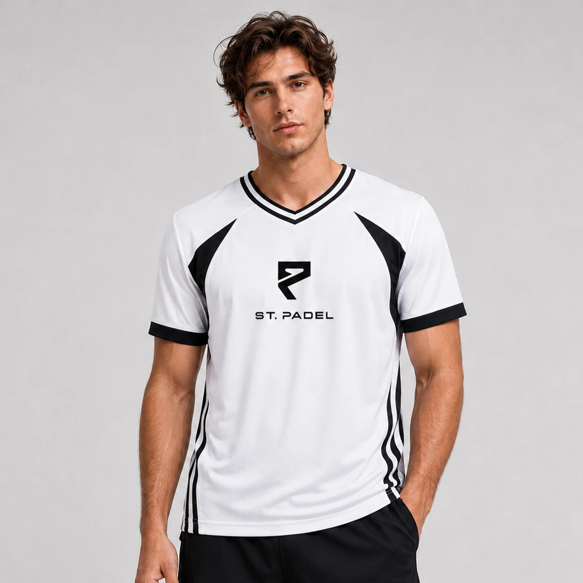 St. Padel V-Neck Jersey. A man wearing a white and black athletic t-shirt with 'ST. PADEL' and a stylized 'R' logo on the chest, photographed against a neutral gray studio background.